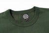 Close-up of a green shirt with a brand label on a white background