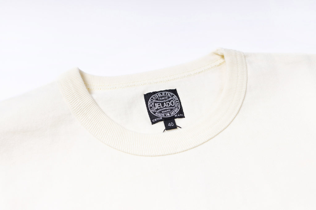 Close-up of a white sweater with a brand label on a white background