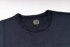 Close-up of a dark navy blue crewneck t-shirt showing the inner neck label which reads 'JELADO'.