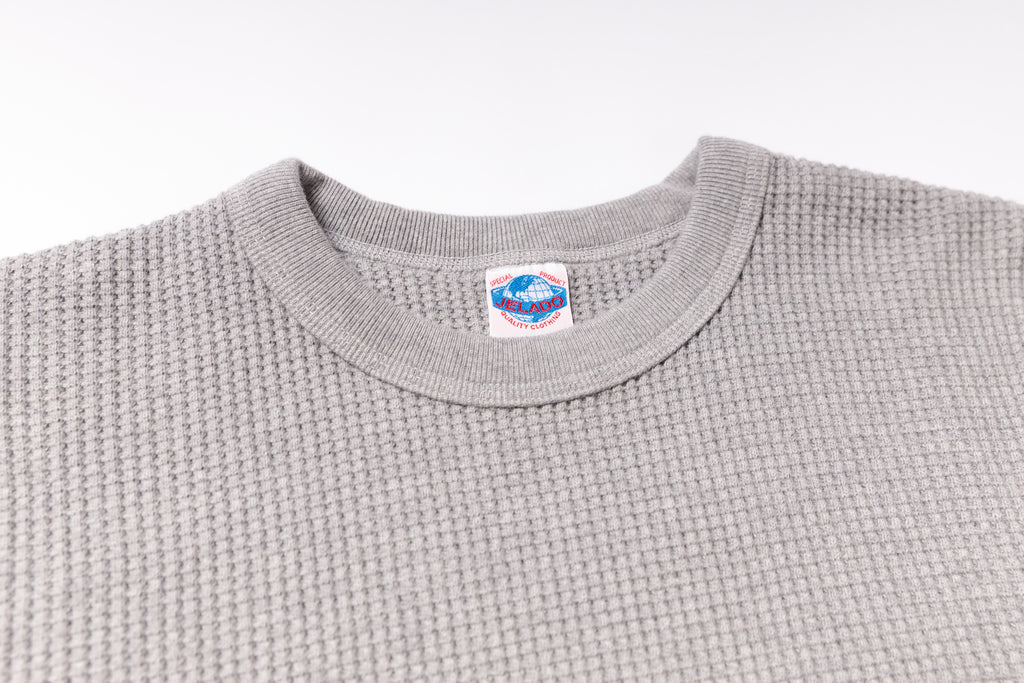 Gray textured sweater with a brand label on a white background