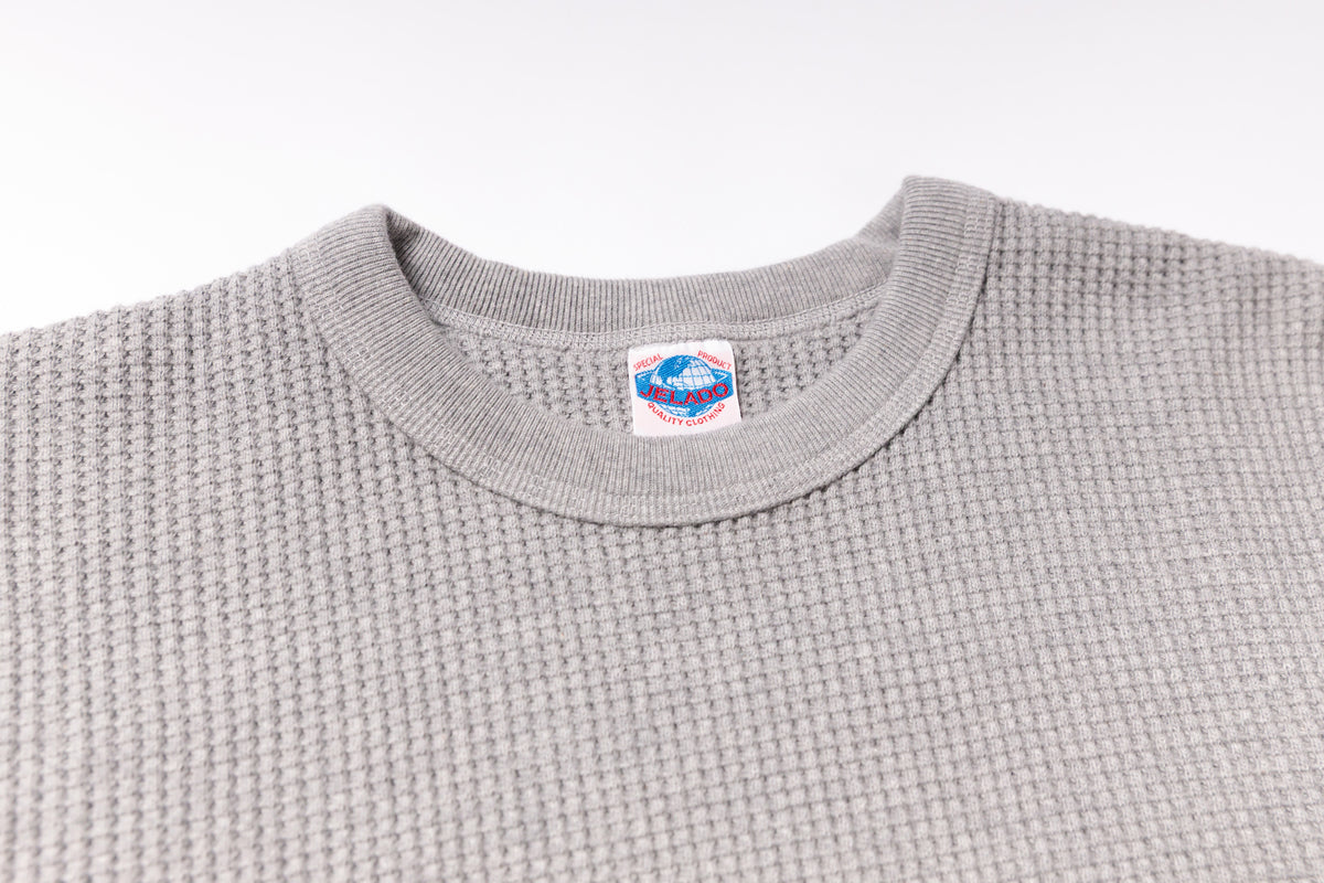 Gray textured sweater with a brand label on a white background