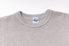 Gray textured sweater with a brand label on a white background
