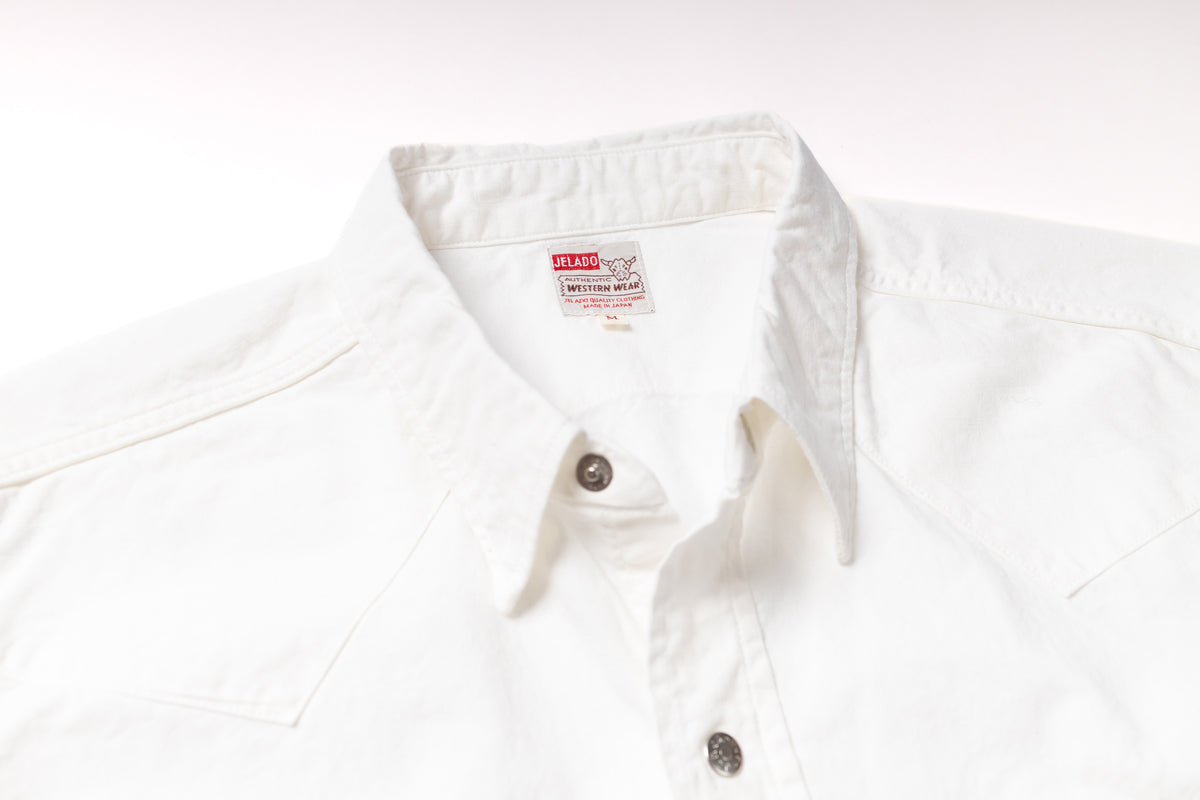Close-up of a white cotton button-down shirt collar with a visible British Airways neck label and dark metal buttons.