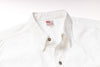 Close-up of a white cotton button-down shirt collar with a visible British Airways neck label and dark metal buttons.