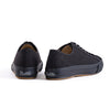 A pair of black low-top canvas sneakers shown from the rear three-quarter angles on a clean white background.