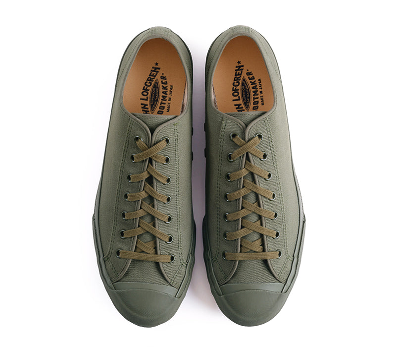A pair of low-top canvas sneakers in olive green with matching green laces, shown from a top-down view on a white background. 
