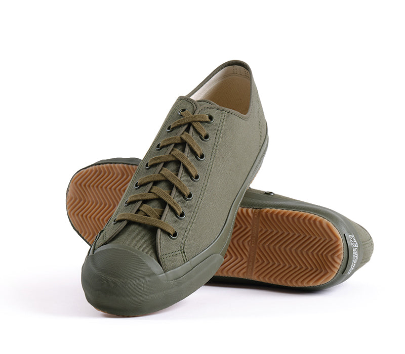 Pair of green sneakers with brown soles on a white background