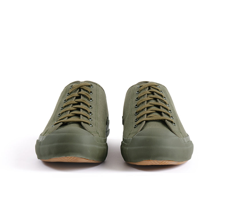A pair of low-top canvas sneakers in olive green, viewed from the front against a plain white background.