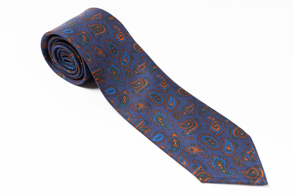 Blue paisley patterned tie on a white background