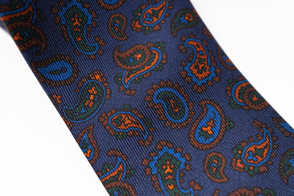 Blue paisley patterned tie on a white background