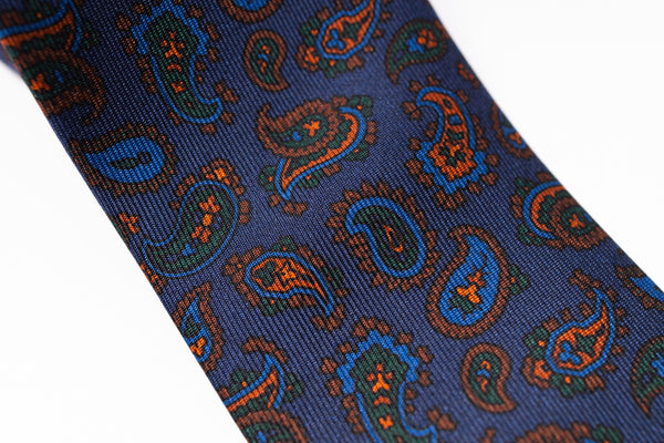 Blue paisley patterned tie on a white background