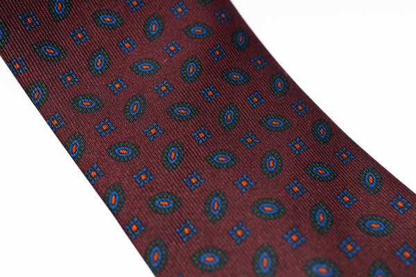 Patterned tie with geometric design on a plain background