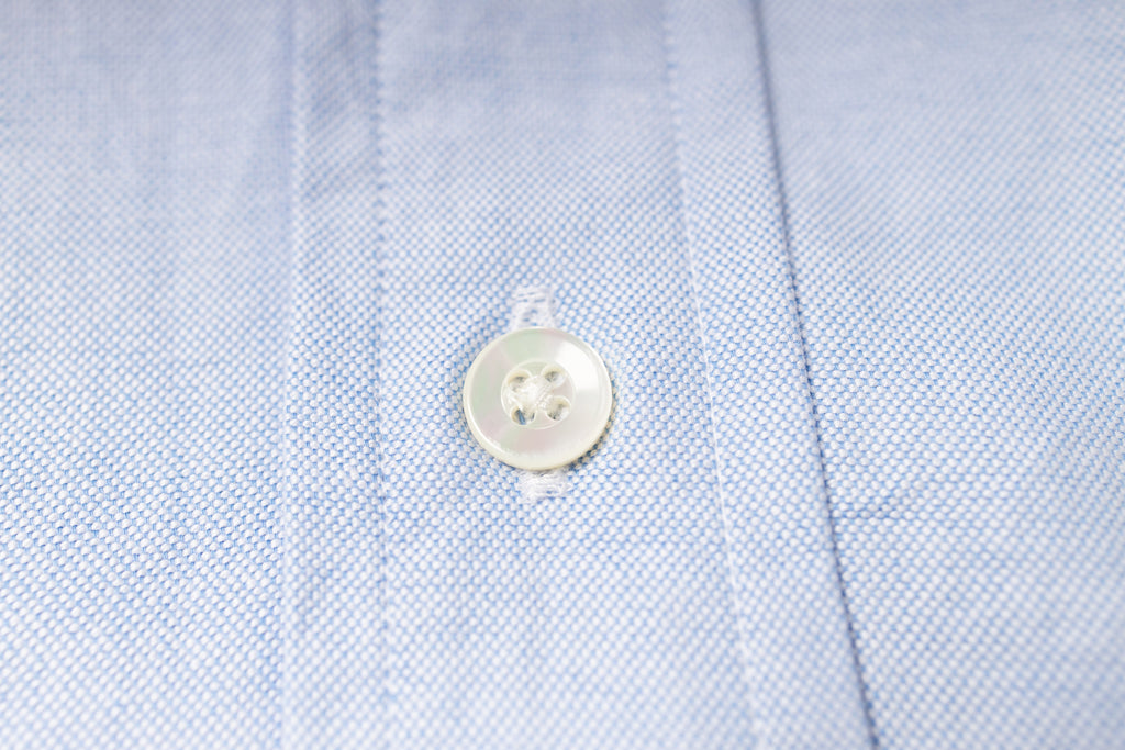 Close-up of a button on an blue fabric shirt