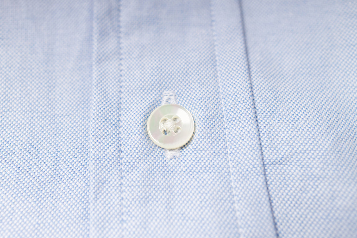 Close-up of a button on an blue fabric shirt