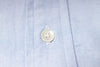 Close-up of a button on an blue fabric shirt