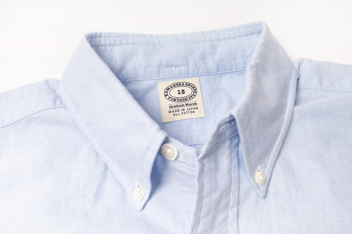 Close-up of a blue shirt with a visible label on a light gray background