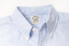 Close-up of a blue shirt with a visible label on a light gray background