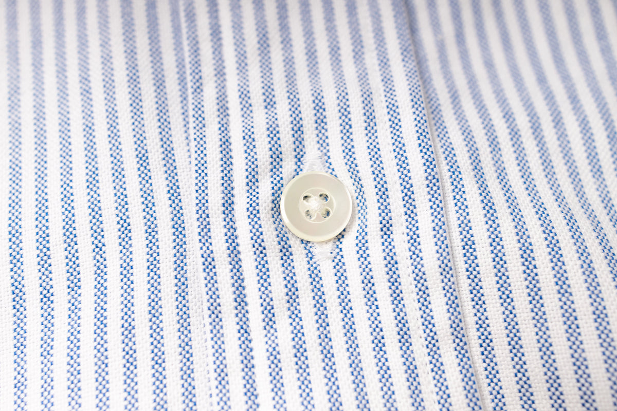 Close-up of a button on a striped fabric shirt