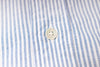 Close-up of a button on a striped fabric shirt