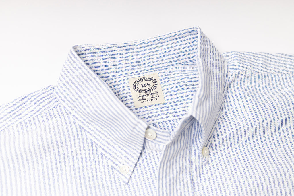 Close-up of a striped shirt with a visible label on a light gray background