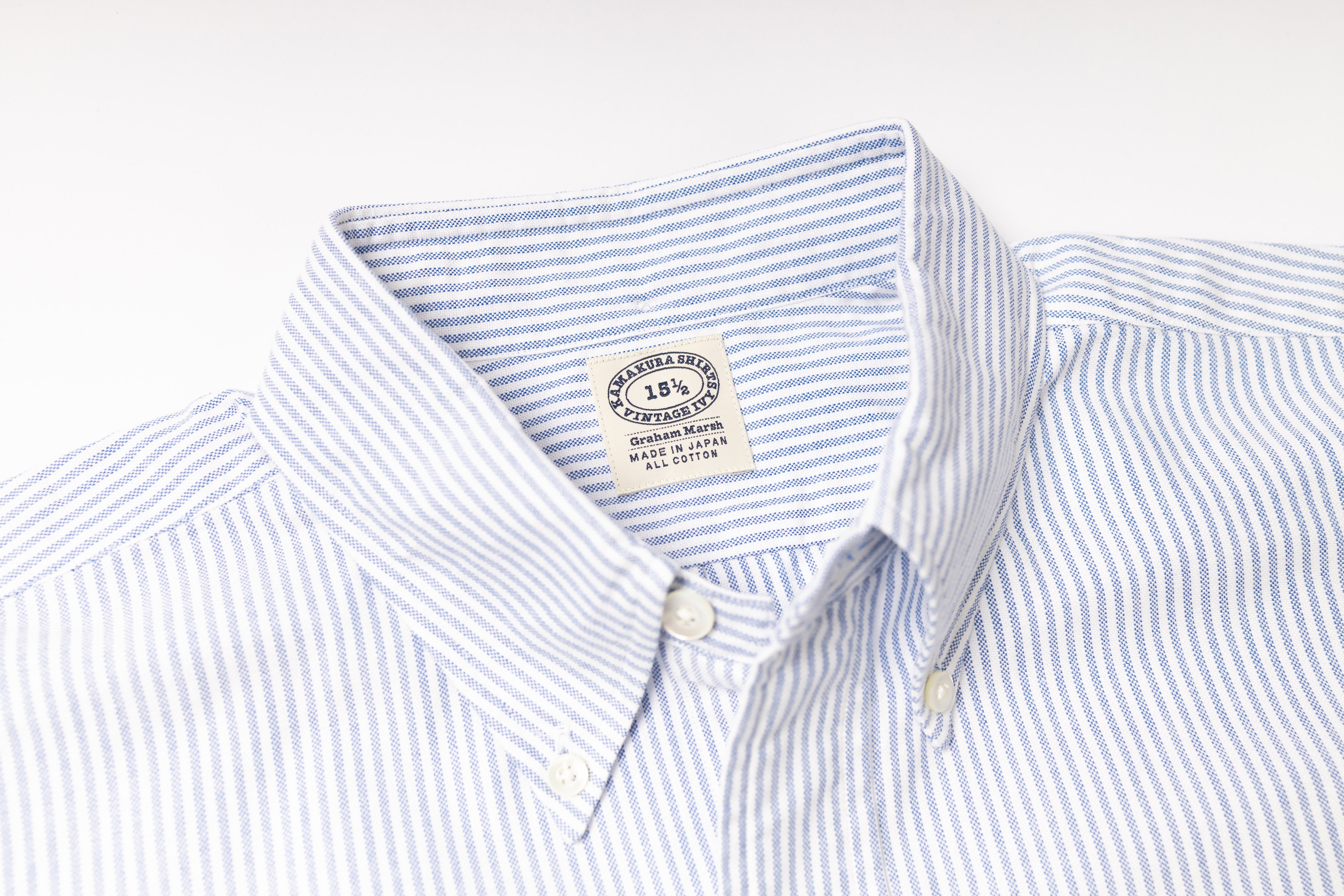 Close-up of a striped shirt with a visible label on a light gray background