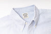 Close-up of a striped shirt with a visible label on a light gray background