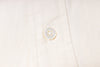 Close-up of a button on an ecru fabric shirt