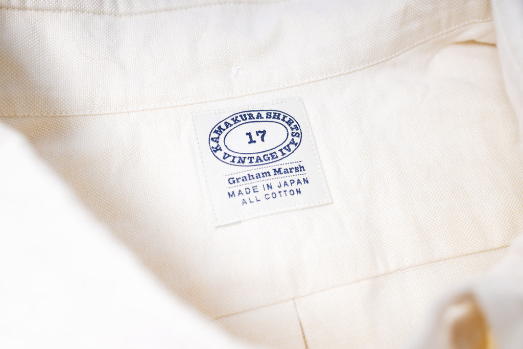 Close-up of a ecru fabric with a label on a white background