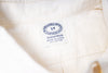 Close-up of a ecru fabric with a label on a white background