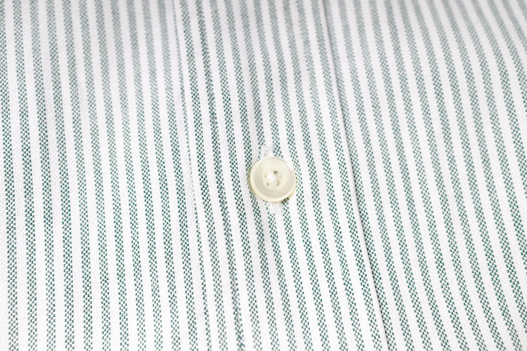 Close-up of a button on a striped fabric shirt