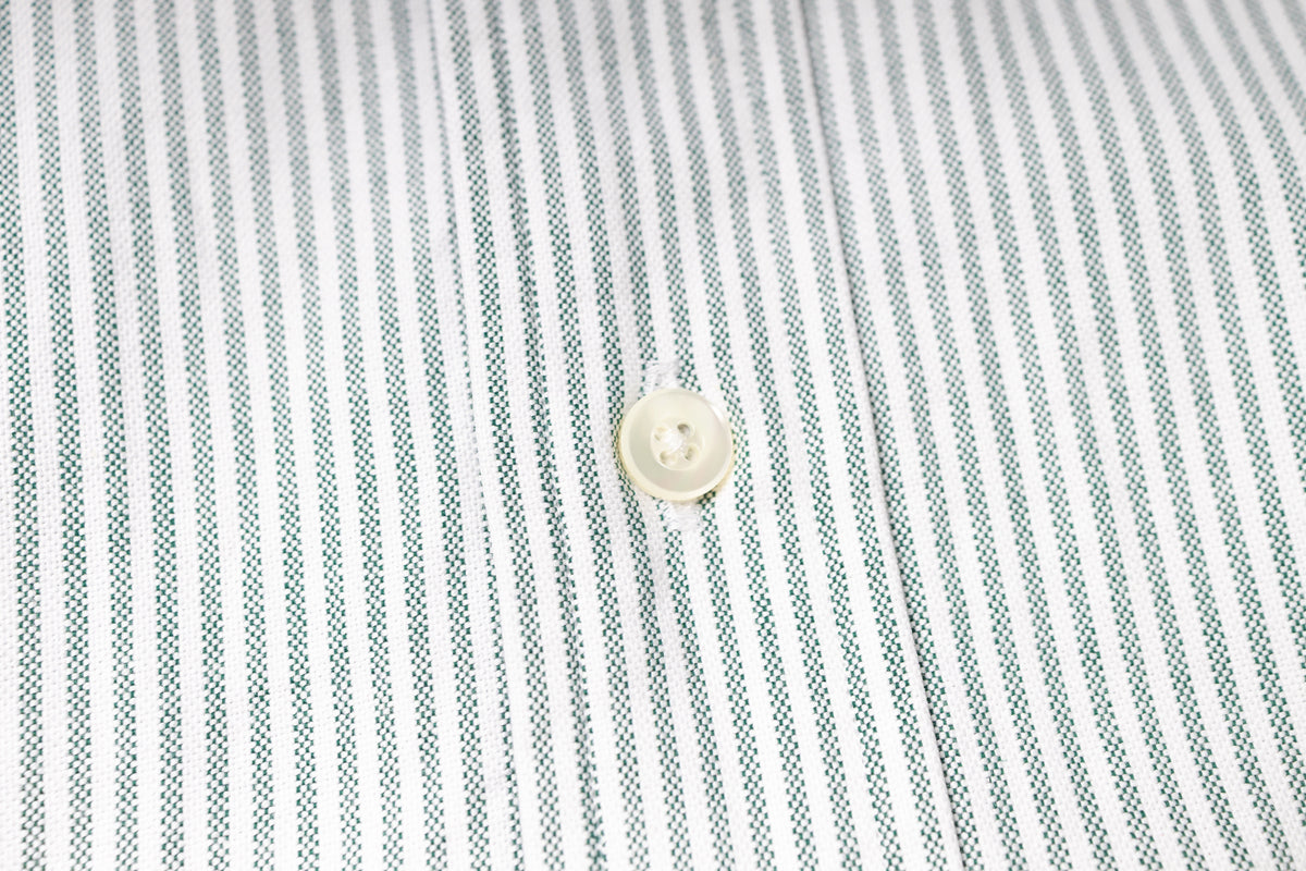 Close-up of a button on a striped fabric shirt
