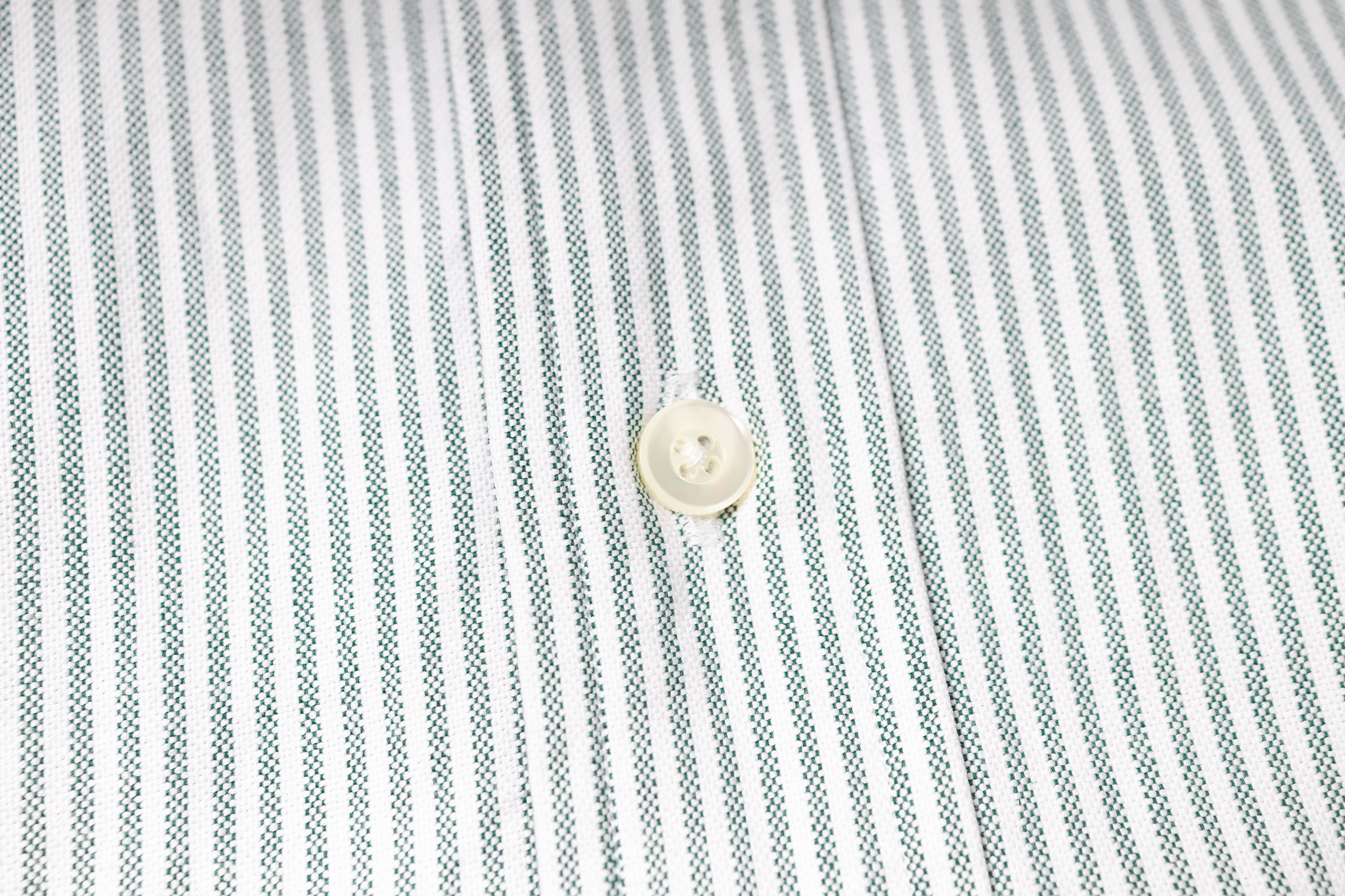 Close-up of a button on a striped fabric shirt
