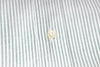 Close-up of a button on a striped fabric shirt