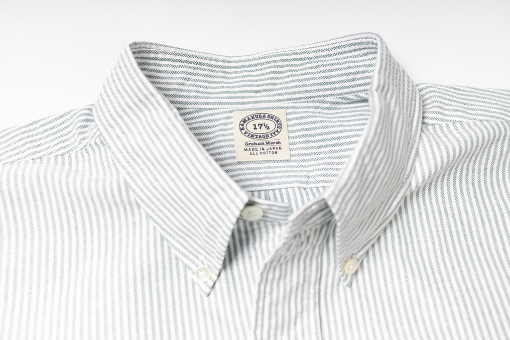 Close-up of a striped shirt with a visible label on a light gray background