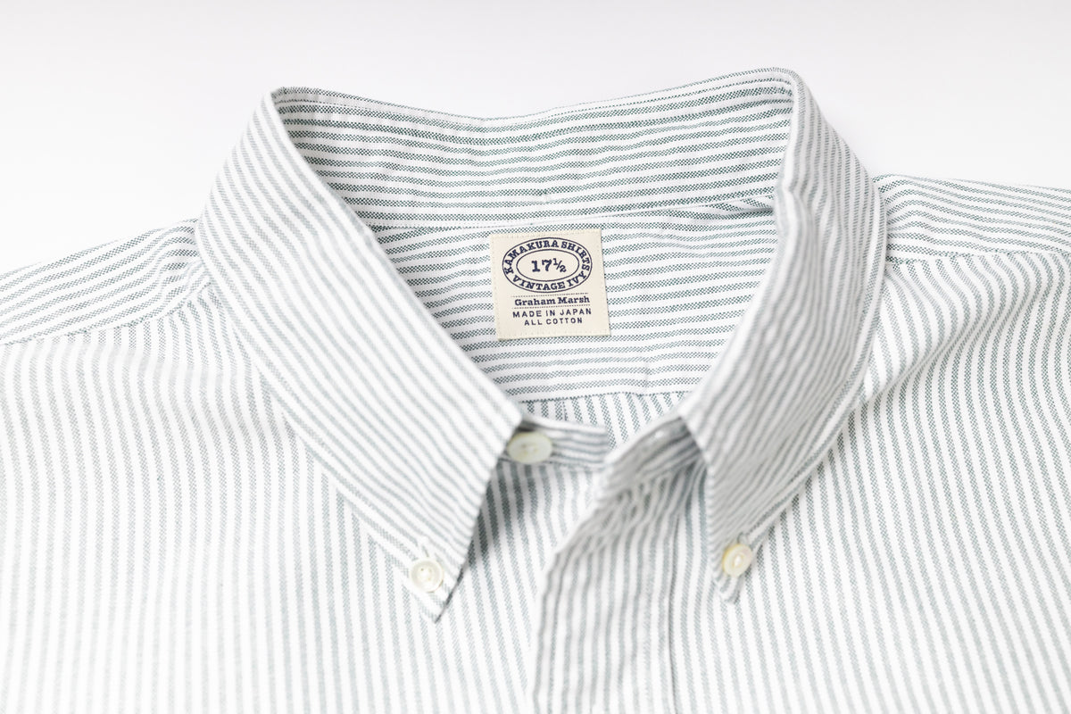 Close-up of a striped shirt with a visible label on a light gray background