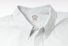 Close-up of a striped shirt with a visible label on a light gray background