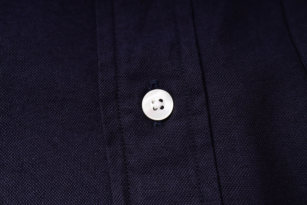 Close-up of a button on an navy fabric shirt