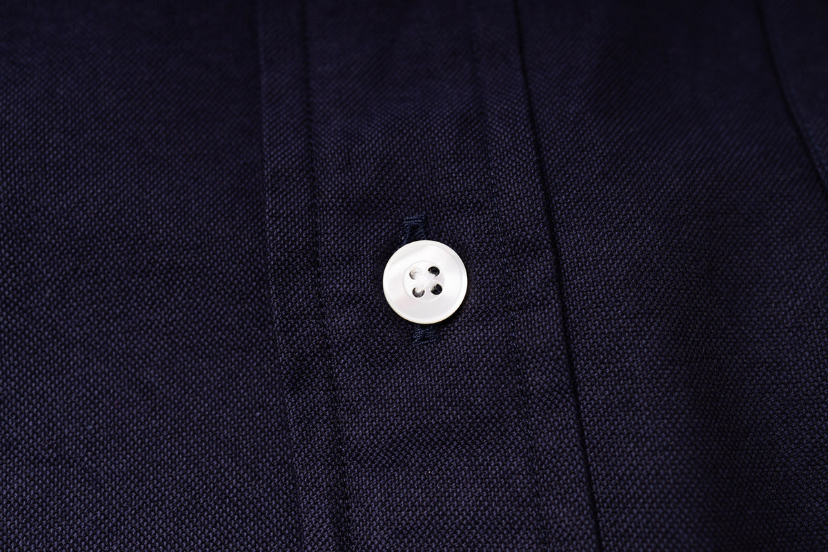 Close-up of a button on an navy fabric shirt