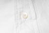 Close-up of a button on an white fabric shirt