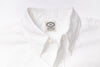 Close-up of a white shirt with a visible label on a light gray background