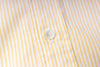 Close-up of a button on a striped fabric shirt