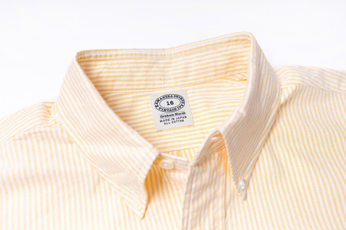 Close-up of a striped shirt with a visible label on a light gray background