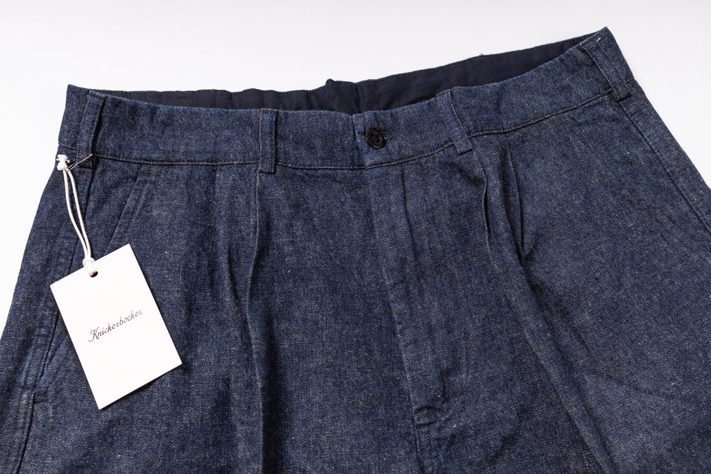 Dark blue pants with a tag on a white background