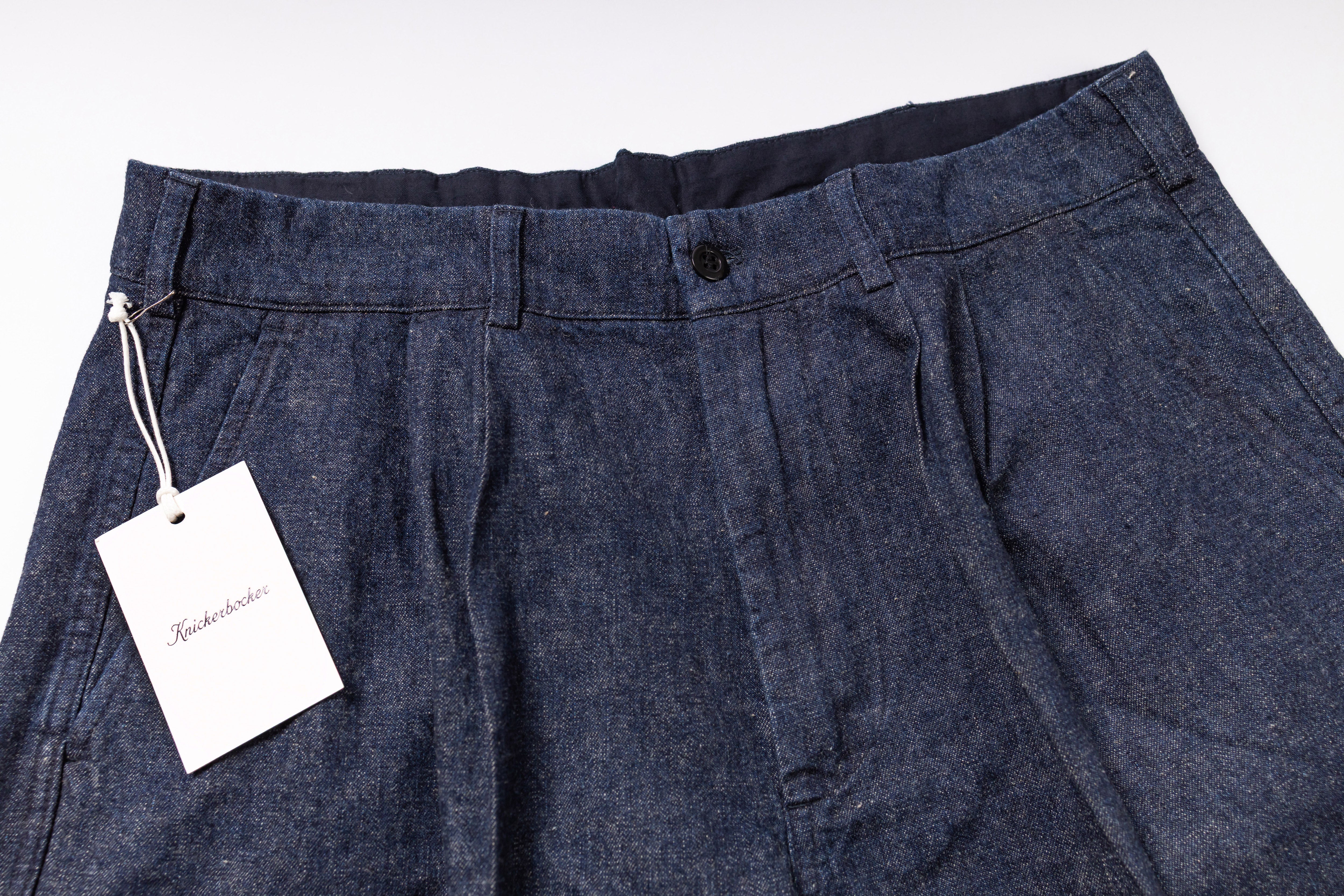 Dark blue pants with a tag on a white background