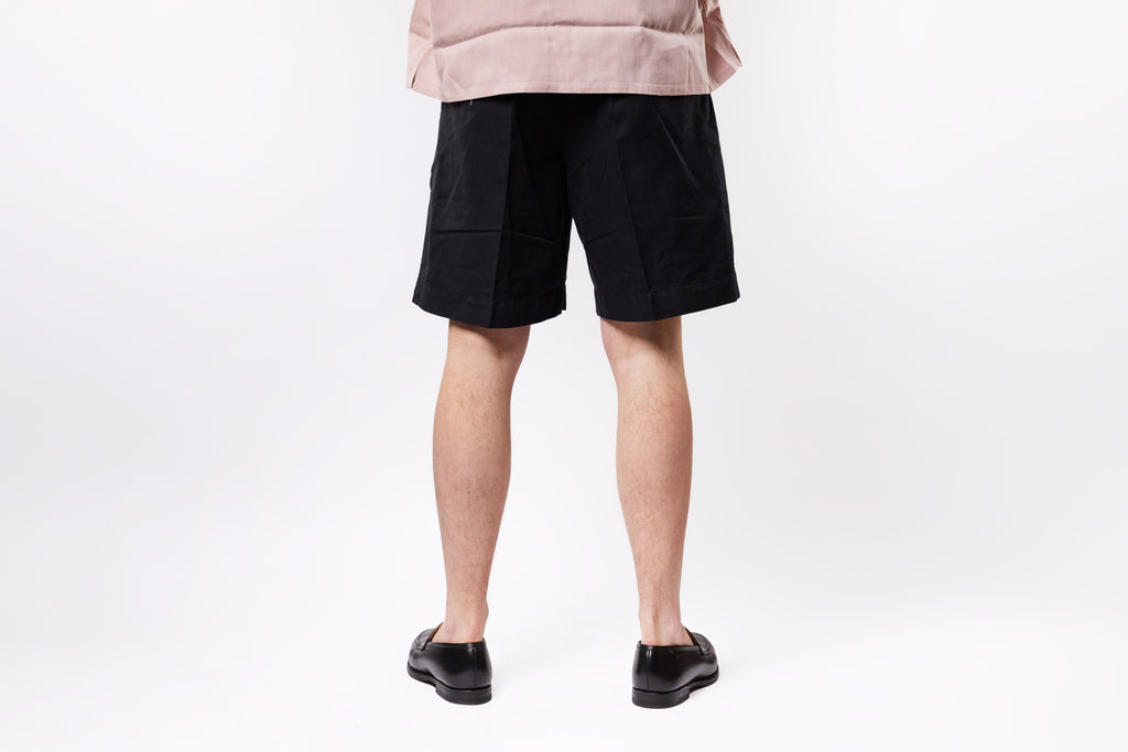 Person wearing black shorts on a white background