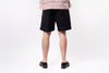 Person wearing black shorts on a white background