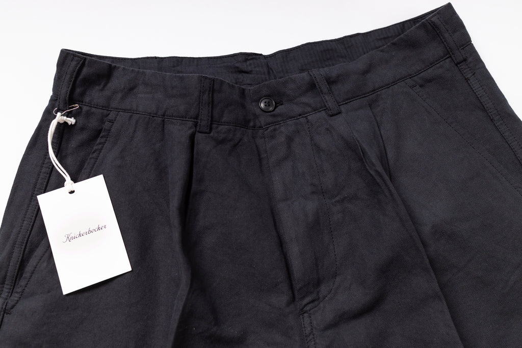 Black pants with a tag on a white background
