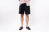 Person wearing black shorts and a light-colored shirt on a white background