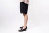 Person wearing a black skirt and black shoes on a white background