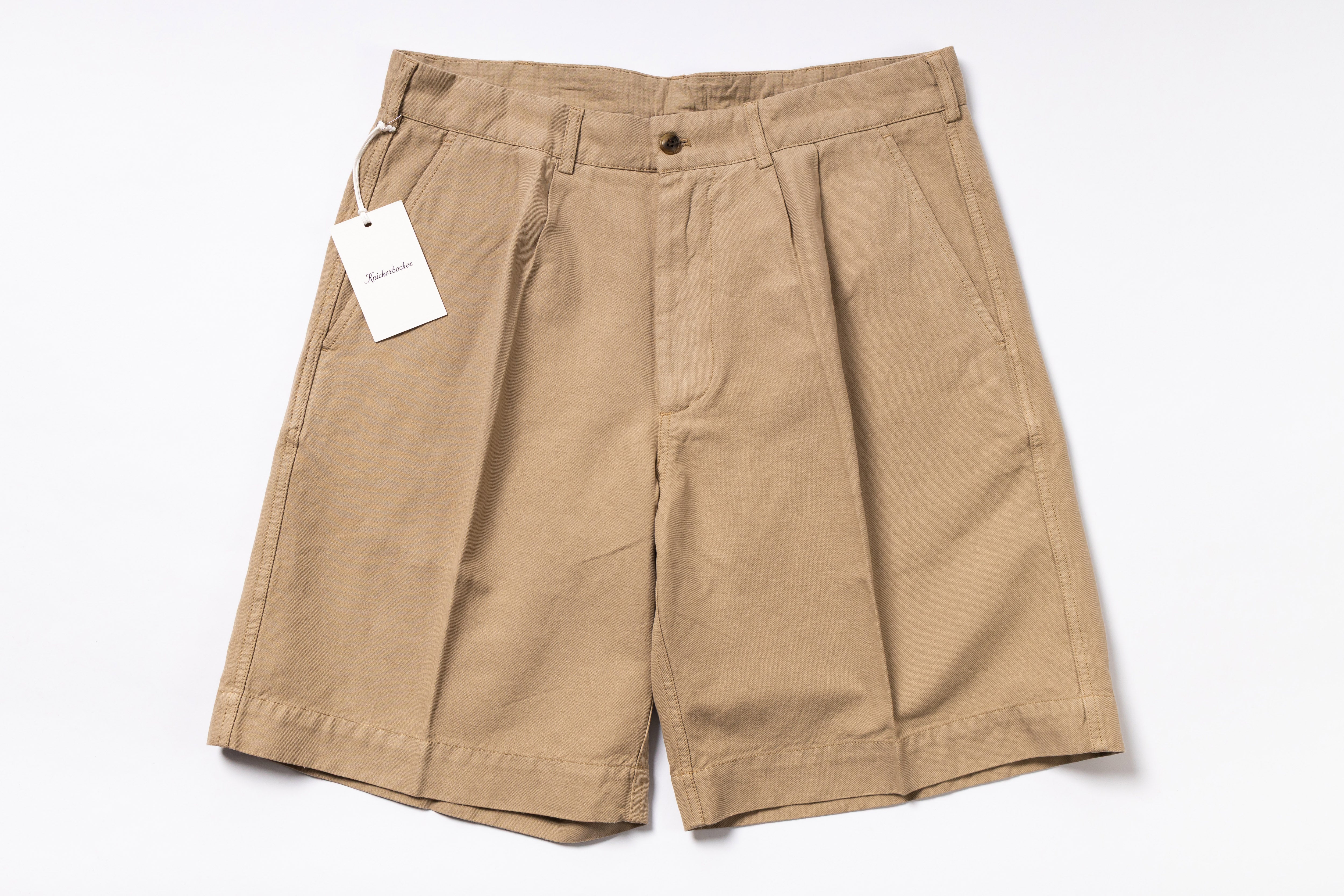 Beige shorts with a tag on a white background